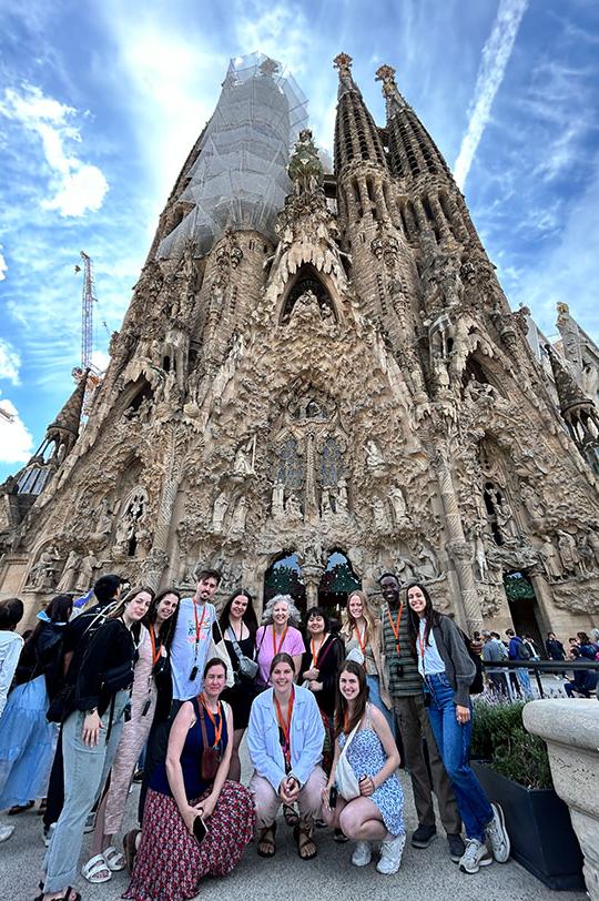 group of students and faculty standing in front of church under construction